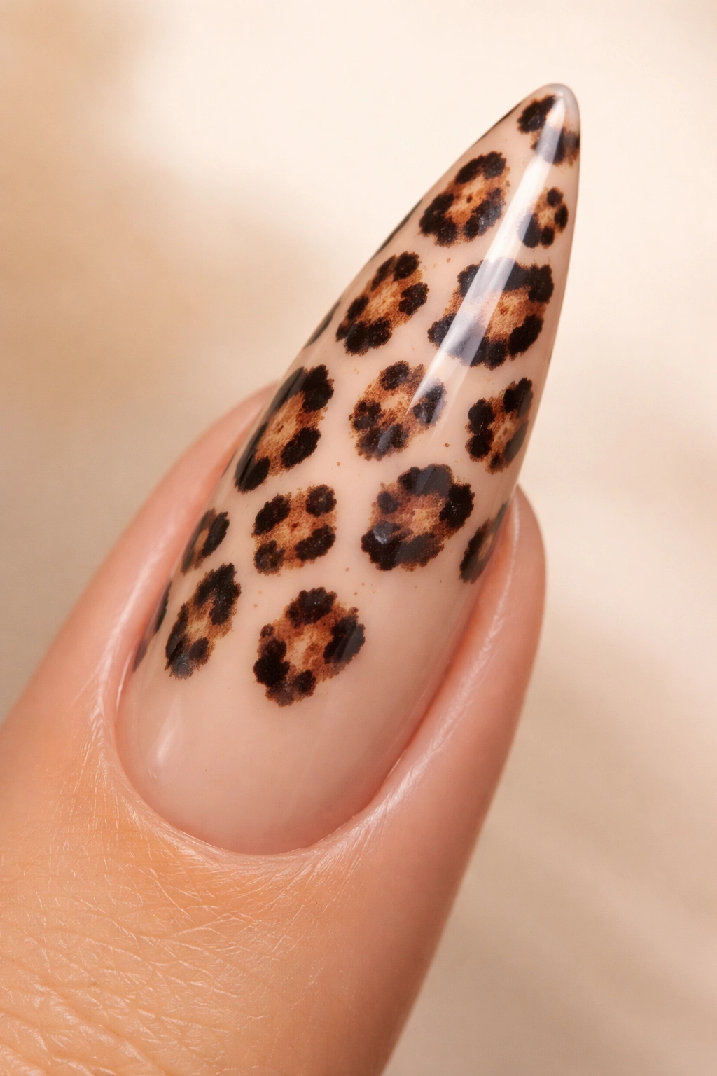 Close-up of leopard-print stiletto nail on warm nude base