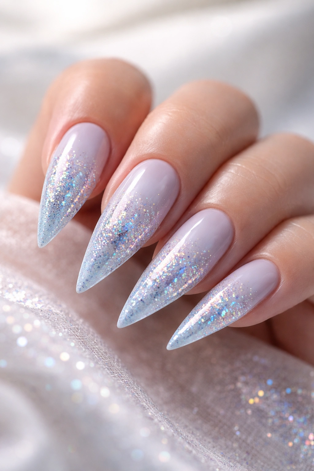 Light blue nails with holographic glitter ombre on stiletto shape