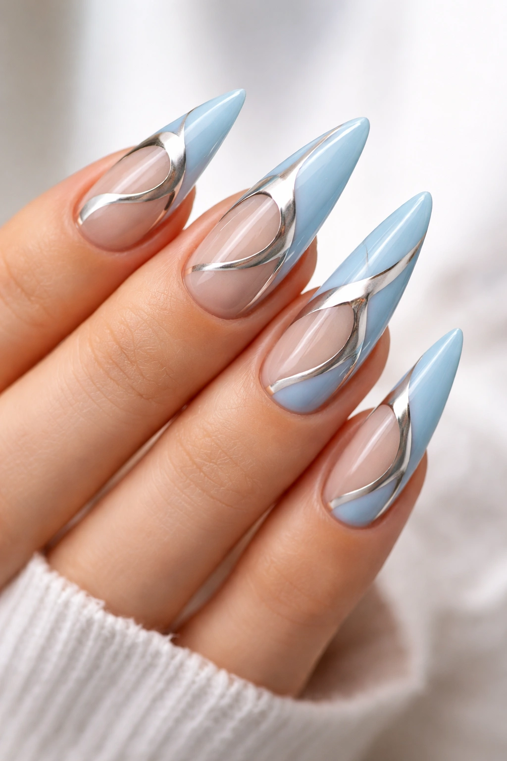Light blue nails with silver negative-space design on stiletto nails