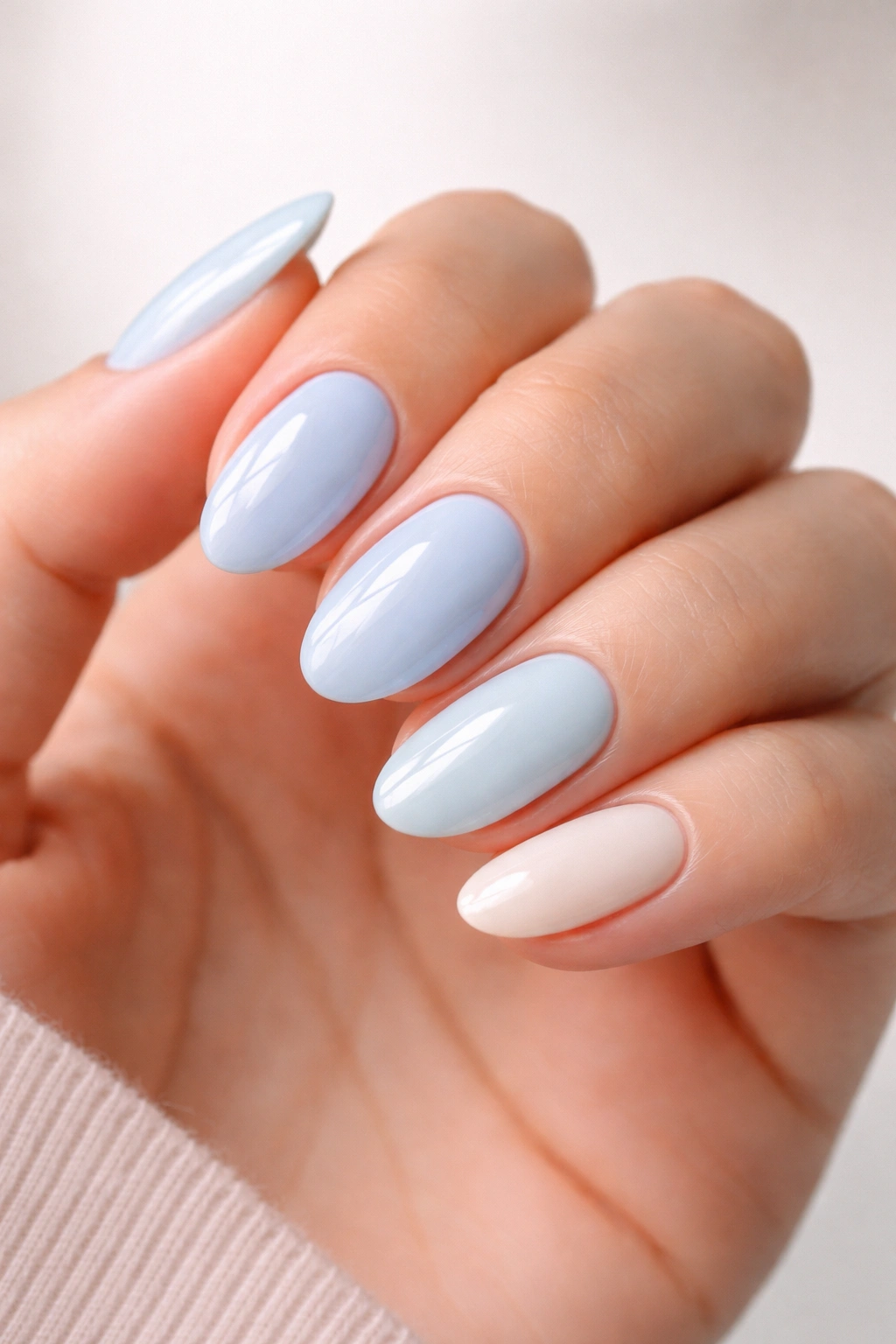 Nail polish shade gradient from icy to creamy blue on short almond nails