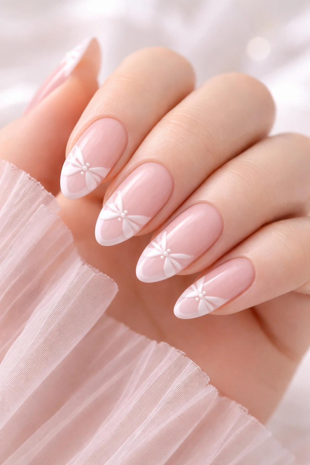 Light pink nails with bow-shaped French tips on almond nails