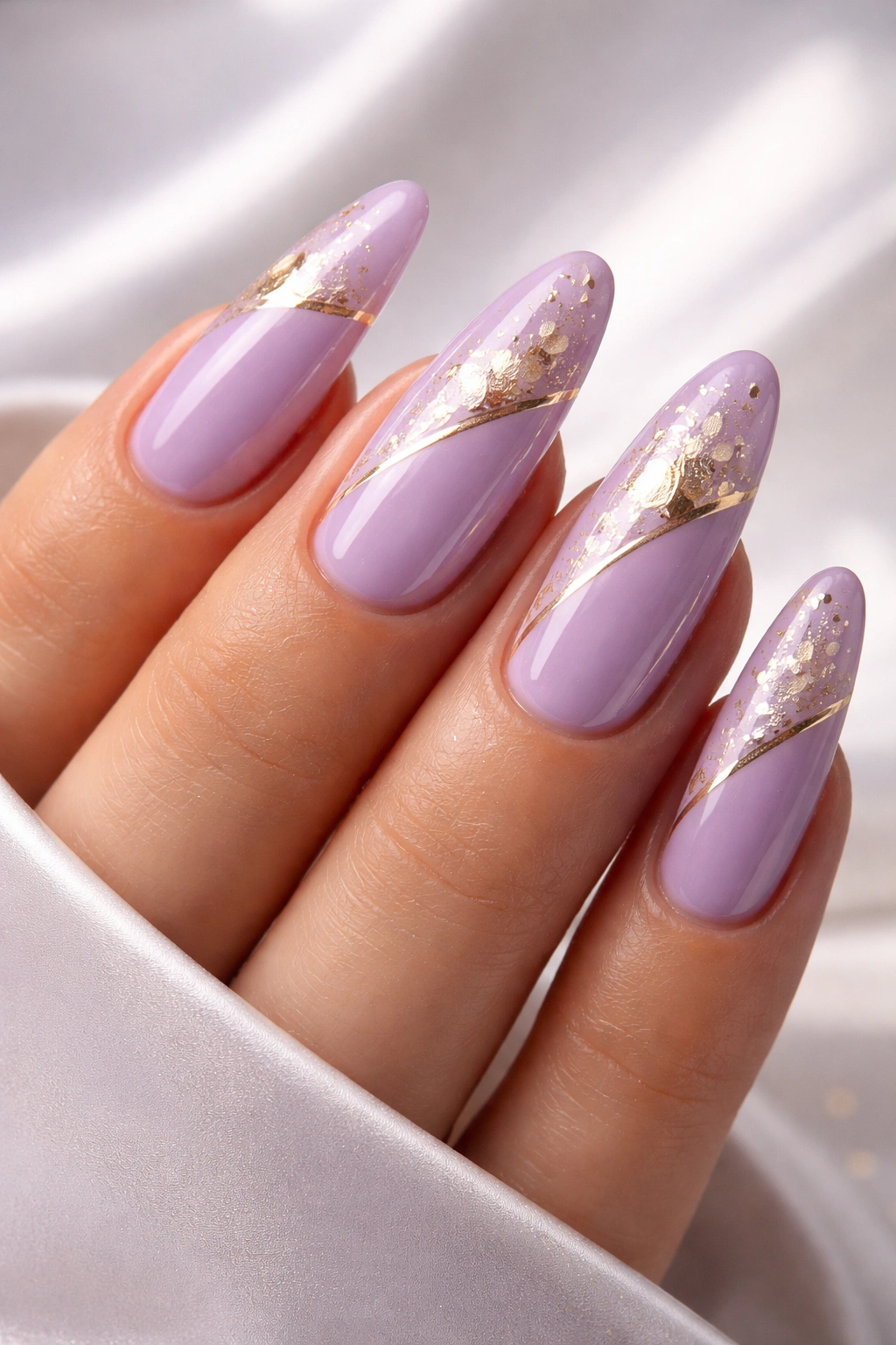 Close-up of lilac nails with gold accents