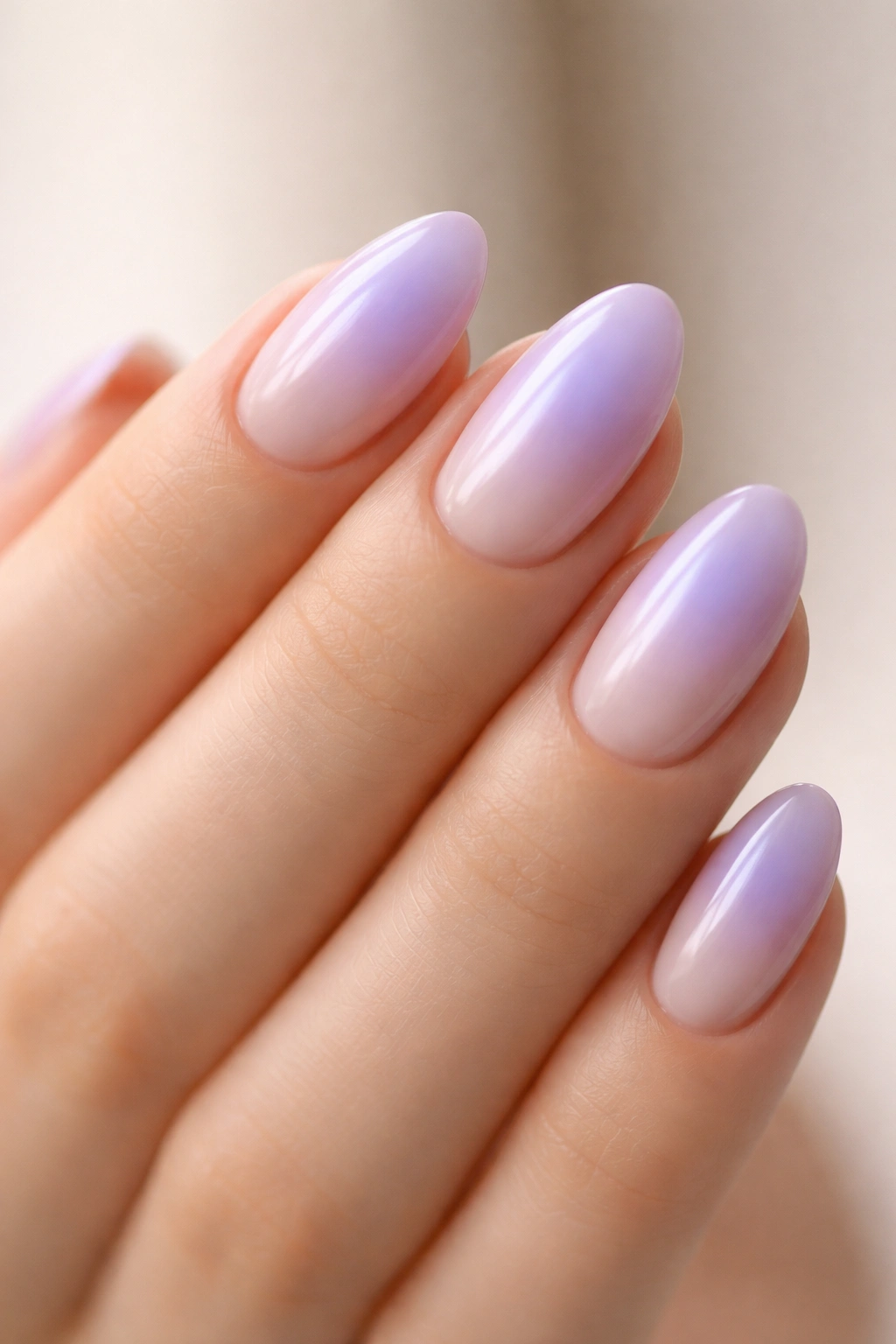 Close-up of lilac aura nails showing a centered soft glow on short almond nails