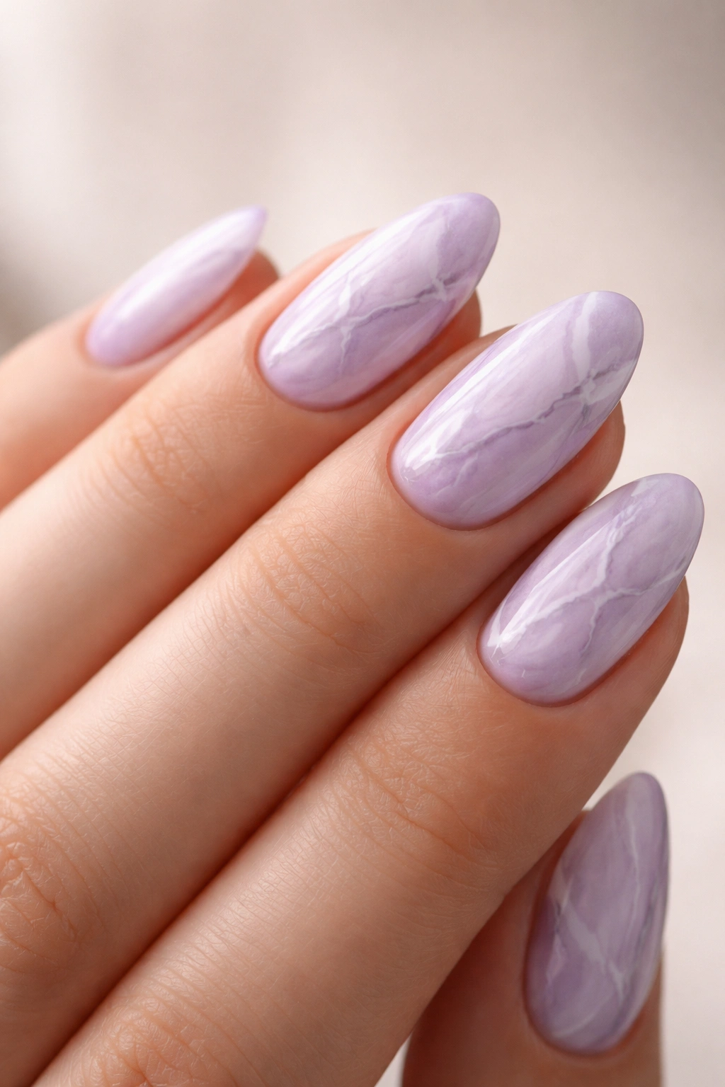 Close-up of lilac marble nails on short almond nails with subtle veins