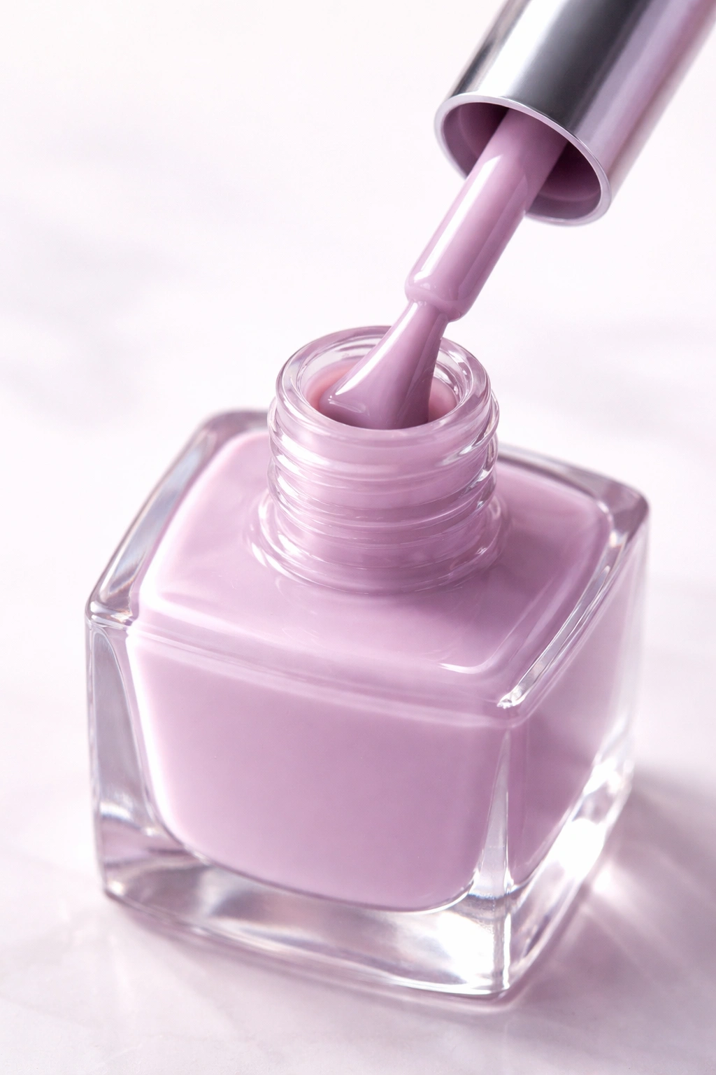 Lilac nail polish bottle with soft purple hue on light background