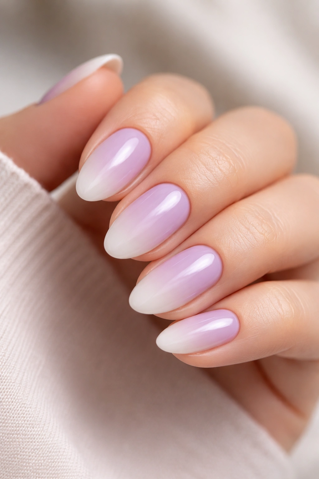 Close-up of lilac to milky white ombré on short almond nails with soft, cloudy transition