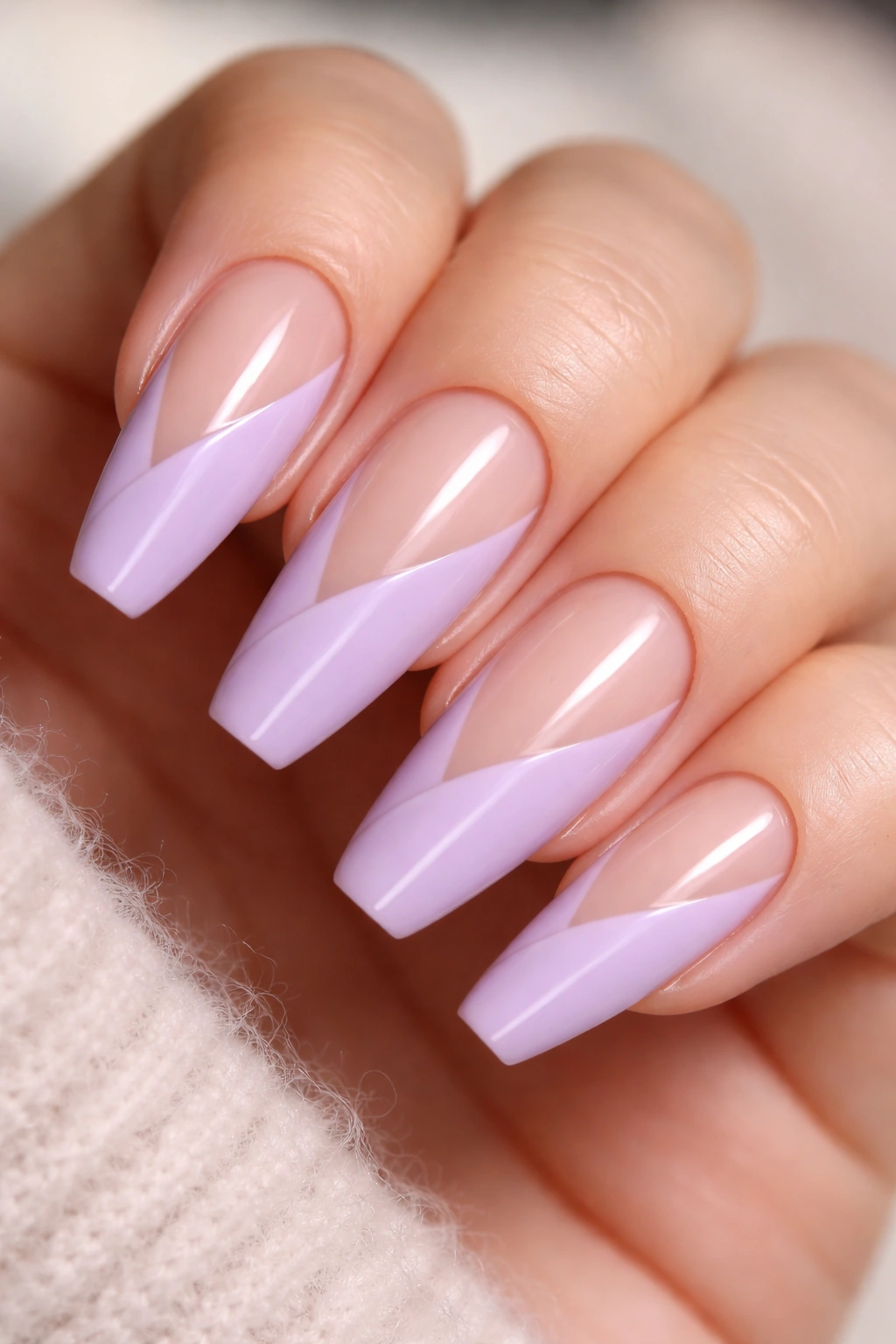 Close-up of a ballerina nail with a diagonal lilac sweep and negative space