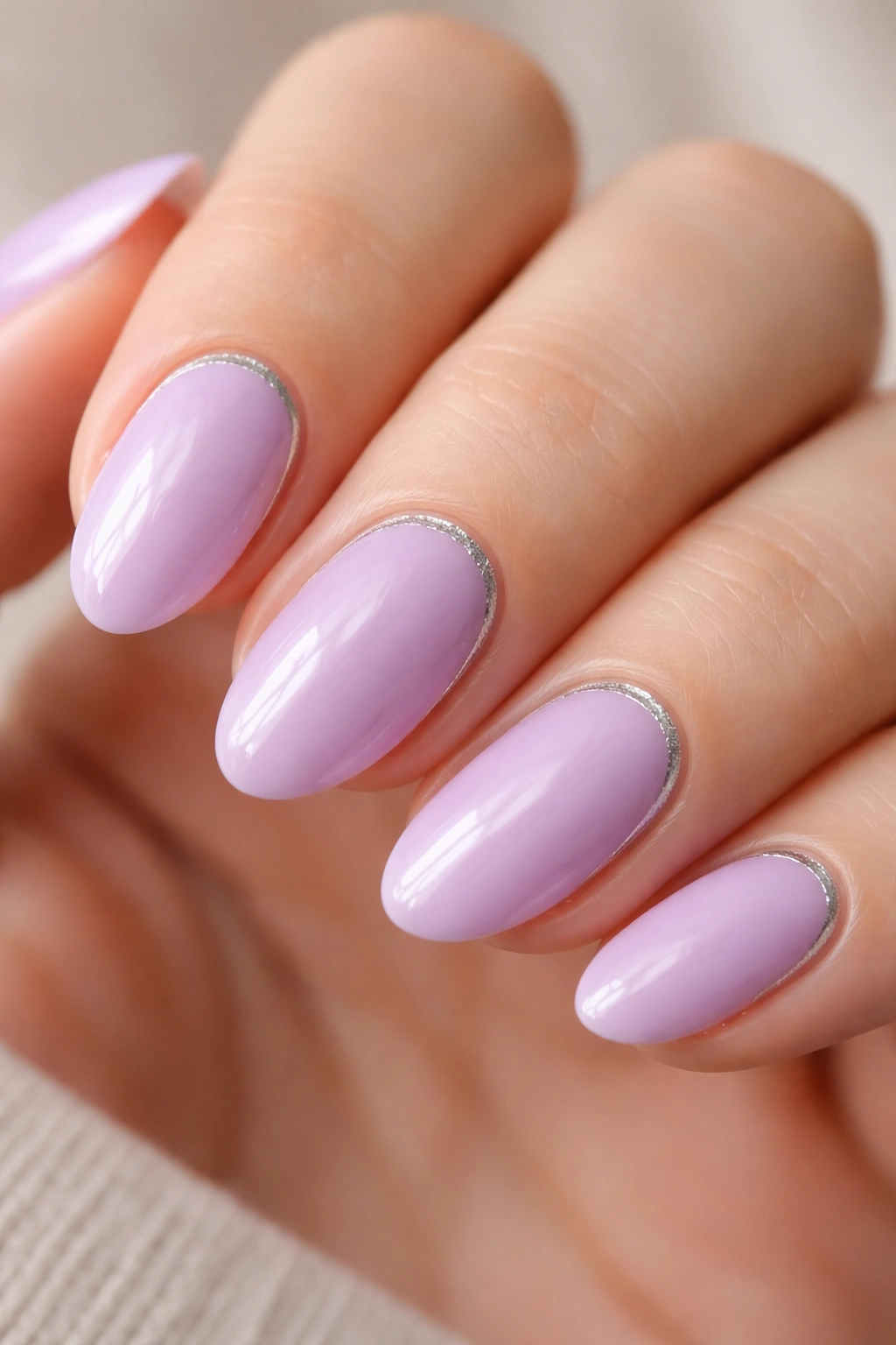 Close-up of lilac nails with a thin silver accent line