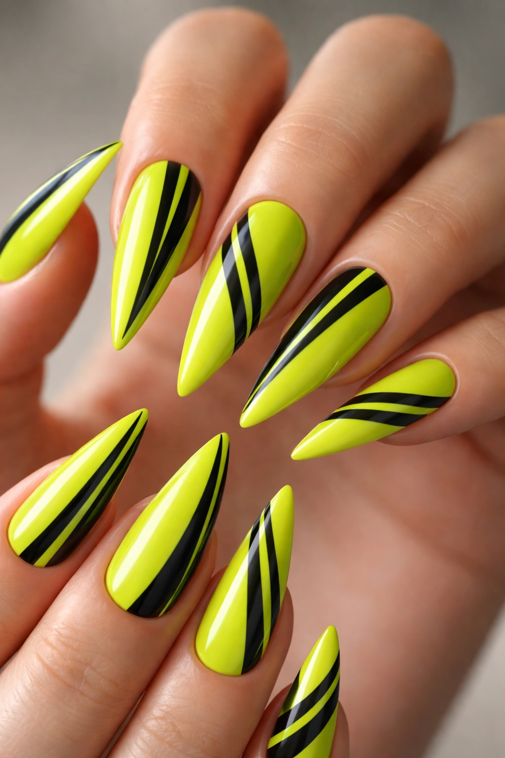 Lime green stiletto nails with black stripes close-up