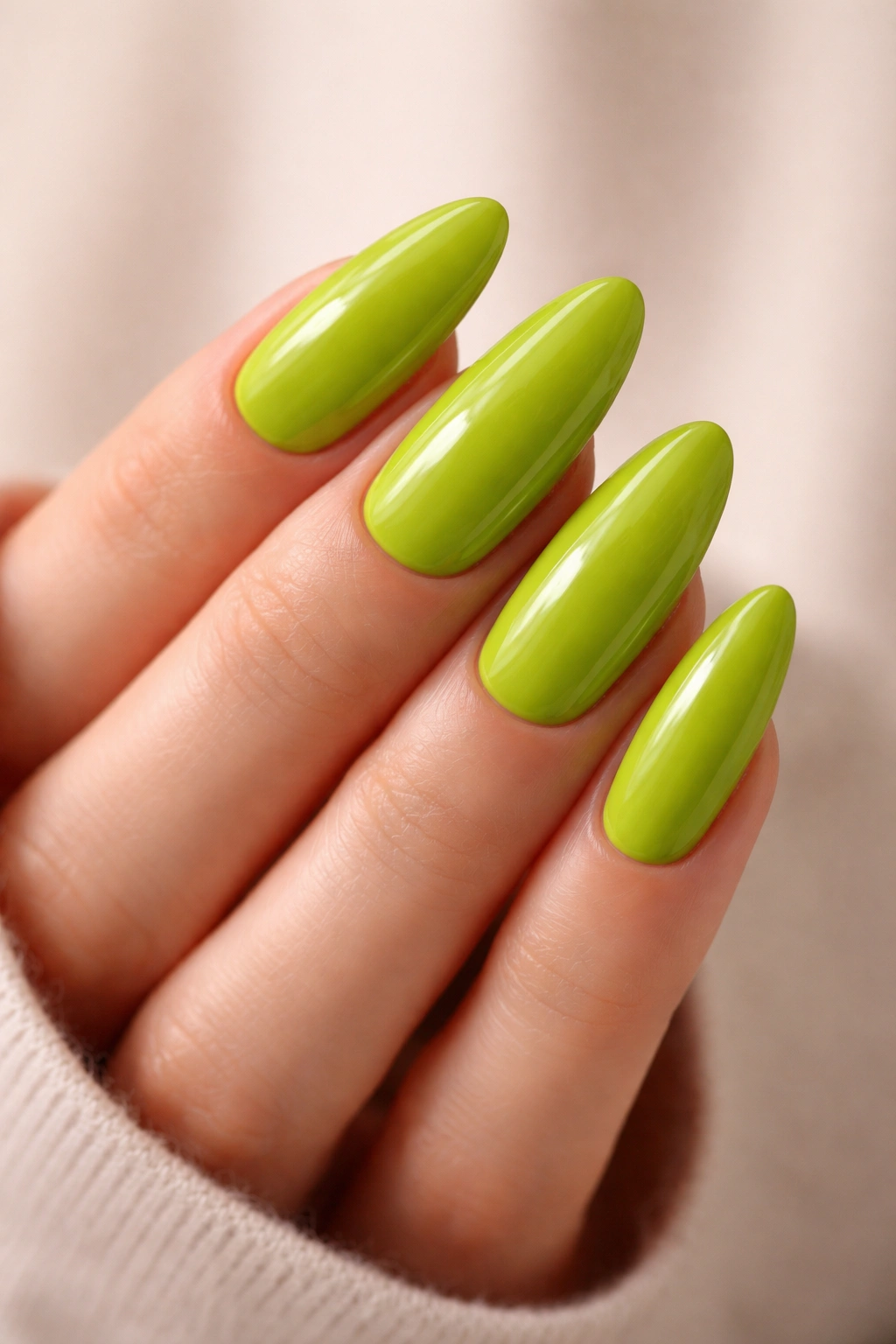Close-up of long oval lime green nails with a crisp glossy shine