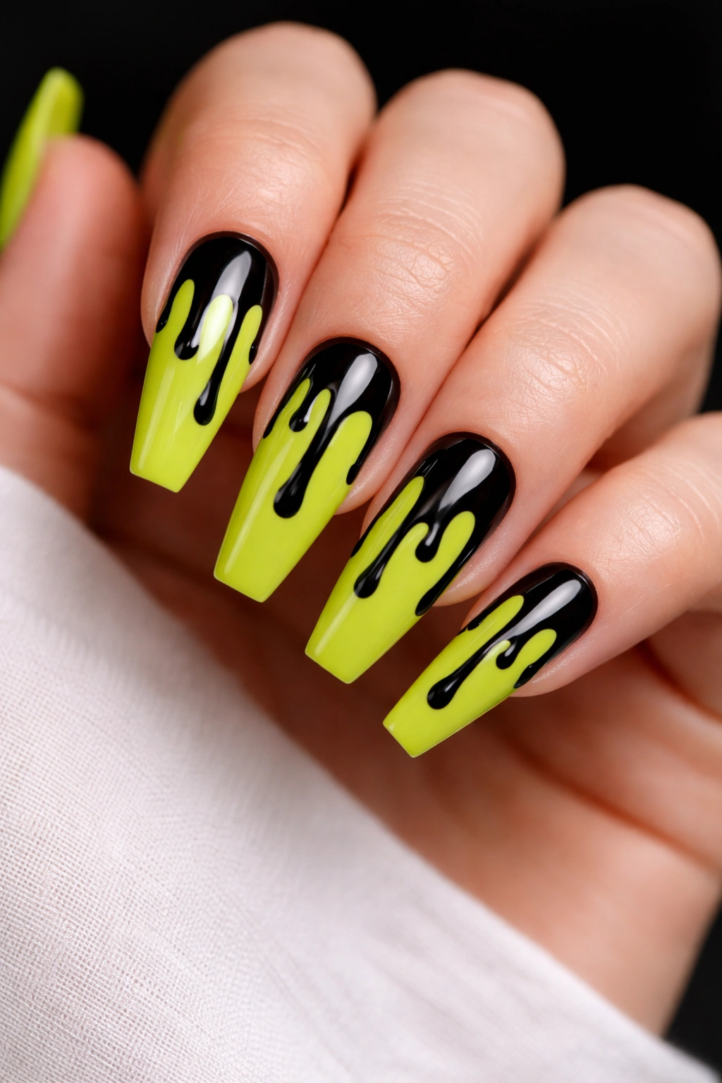 Coffin nails in neon lime with black drip designs.