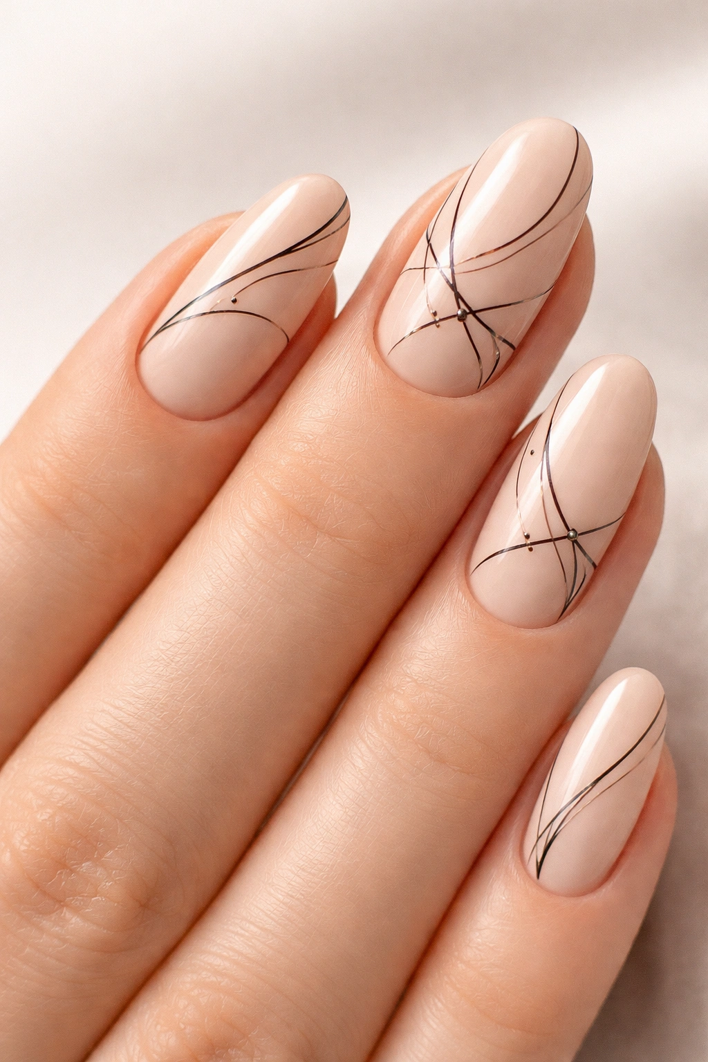 Nails with fine black line art on nude base