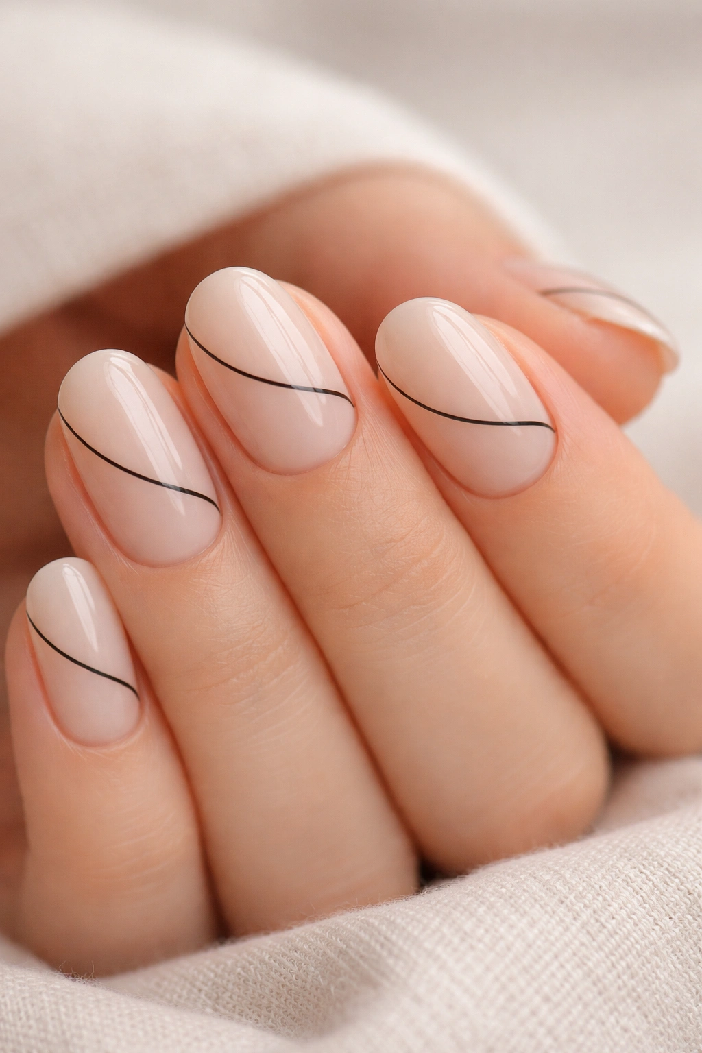 Close-up of minimal line art on short oval nails with one thin black line