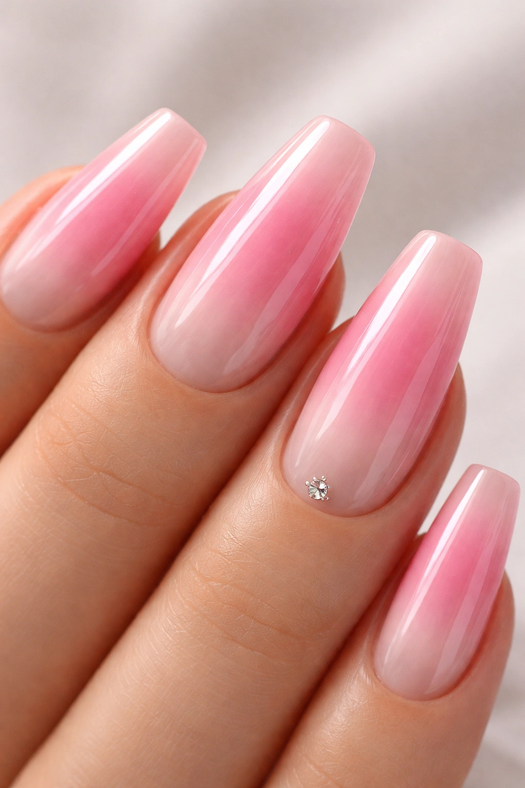 Lip-gloss pink ombré on ballerina nails with glassy finish.