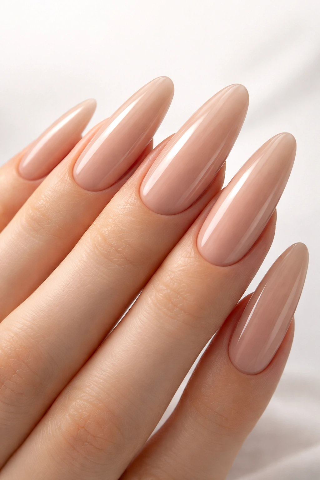 Hand with long nude nails and polished finish on a clean background