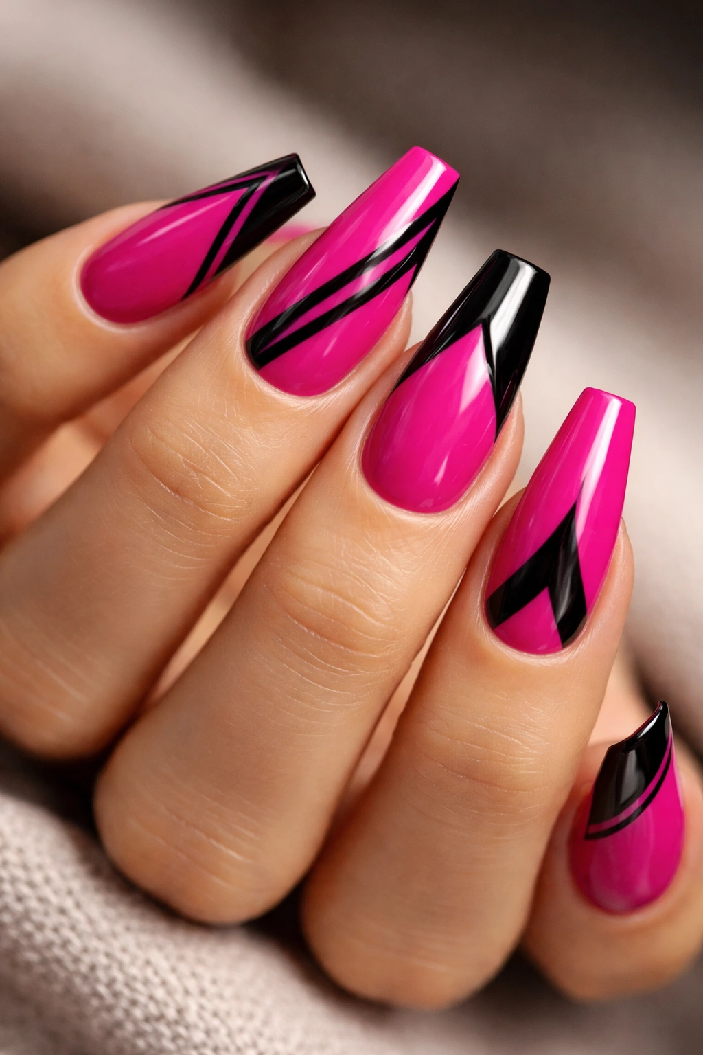 Close-up of a hand with medium coffin nails magenta and black detail design