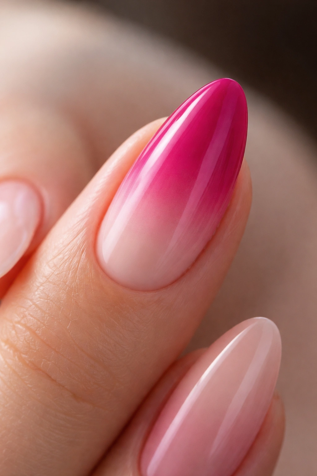 Close-up almond nail with magenta to blush ombre gradient