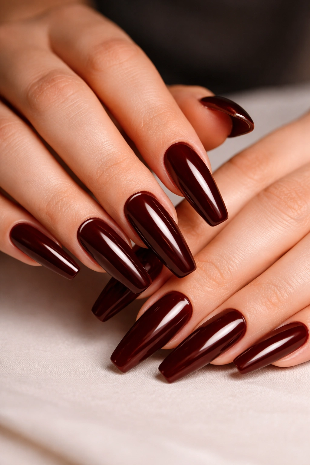 Close-up of deep mahogany ballerina nails with a sharp high-gloss finish