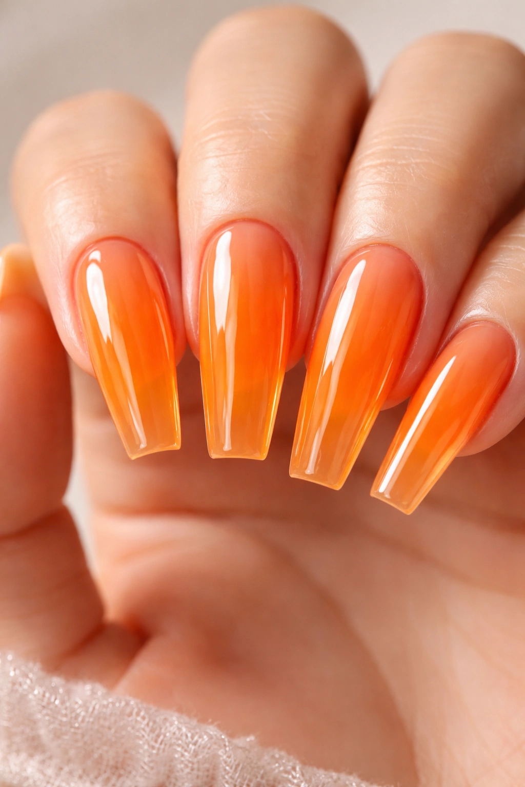 Close-up of translucent mandarin jelly nails showing glass-like depth.