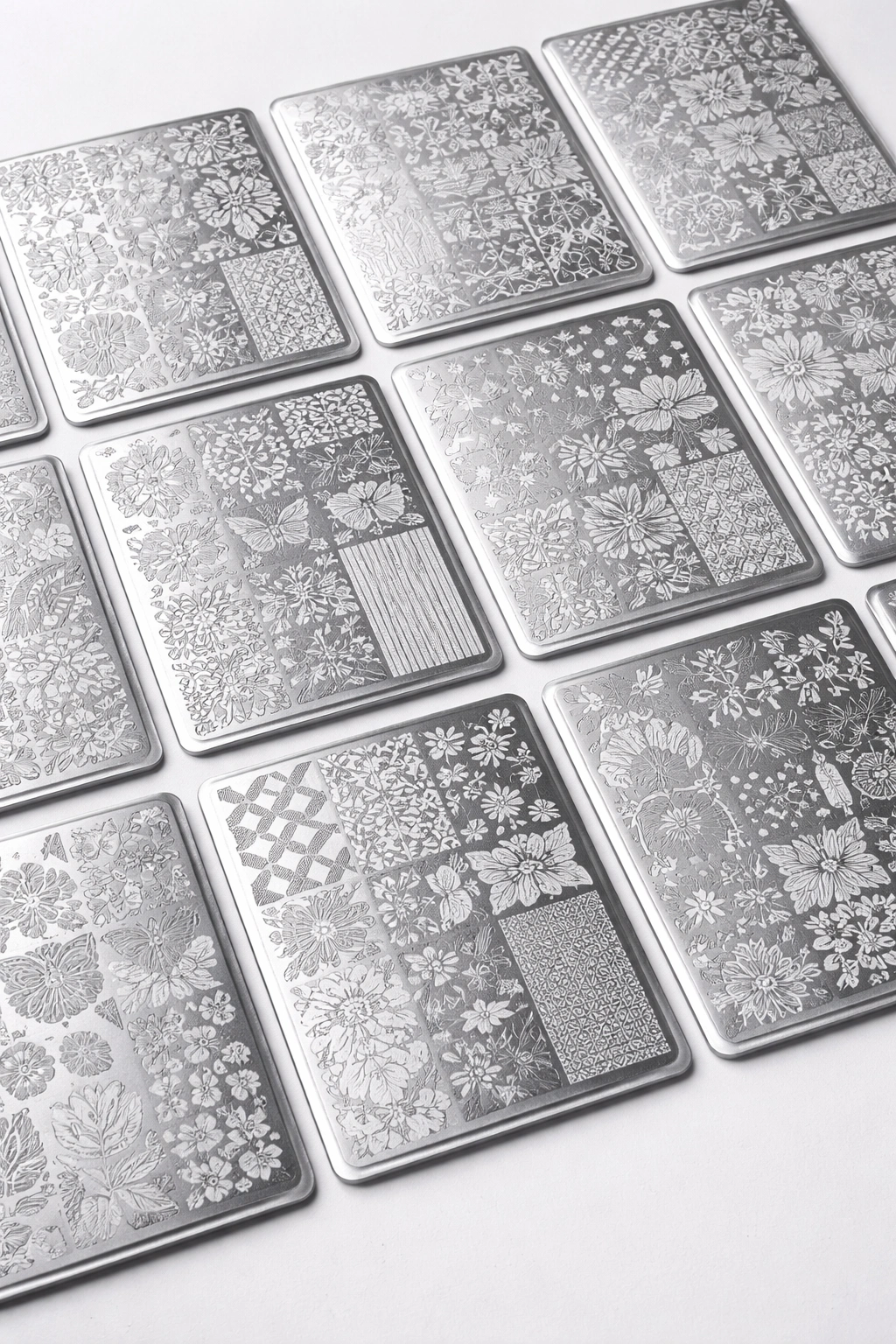 Maniology stamping plates arranged in a grid on a white surface