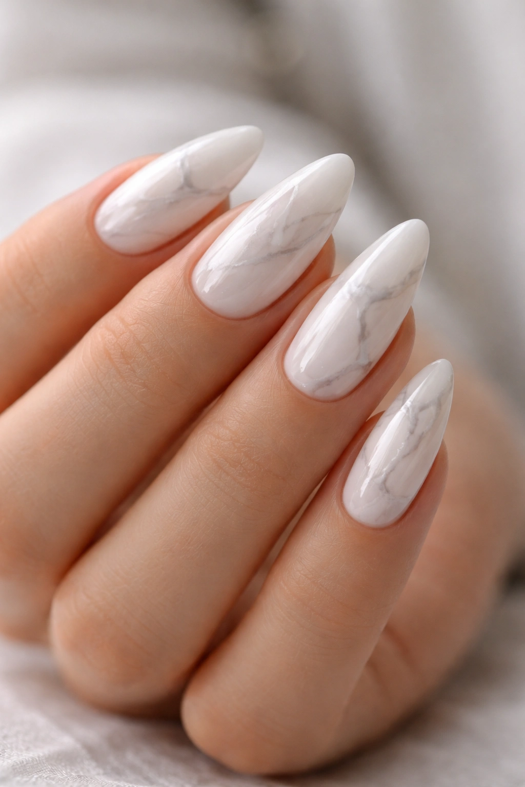 Almond nails with white and gray marble veining on milky base