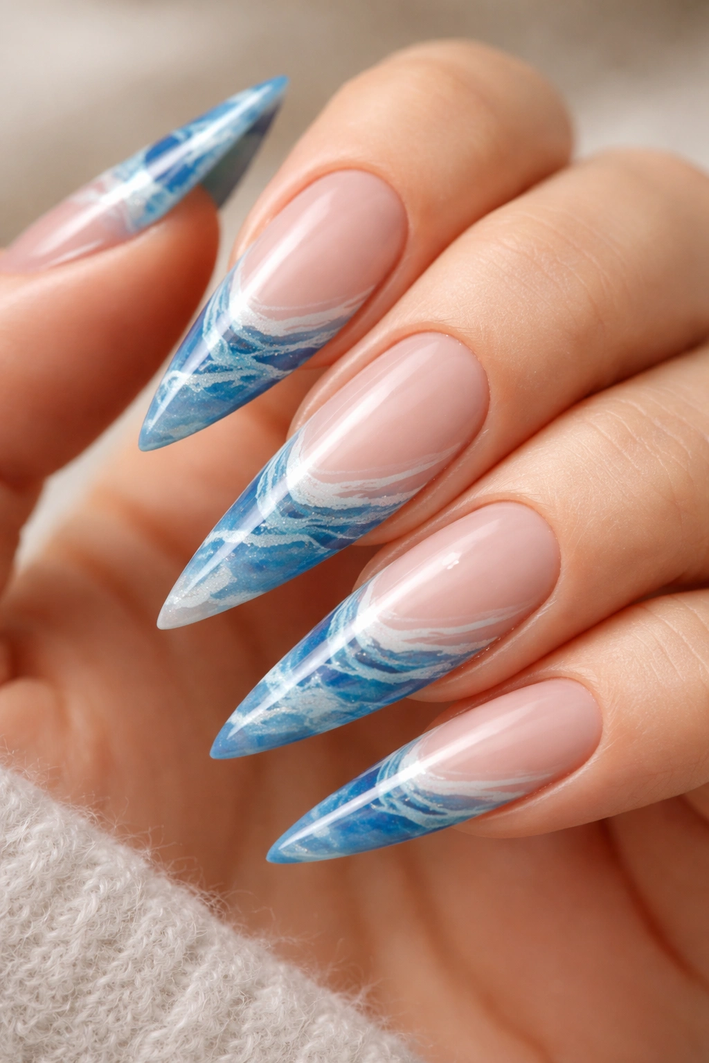 Close-up of marble blue French tip nails on stiletto shape