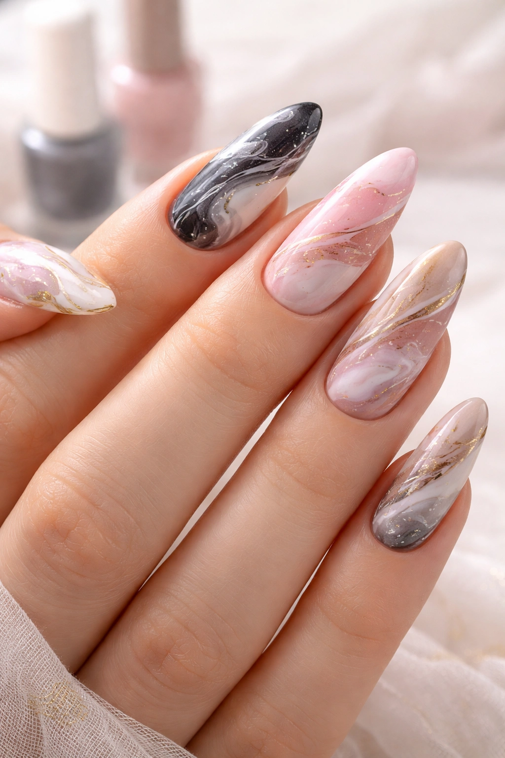 Nails with marble art featuring black, white, gray, pink, and nude tones