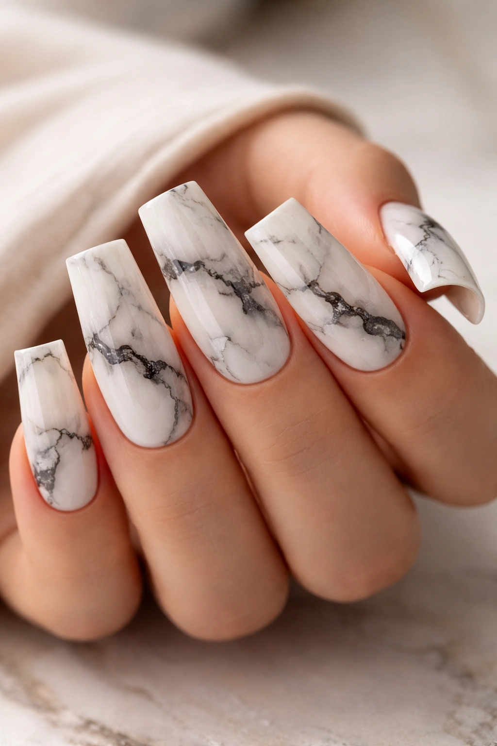 Duck nails with marble veining on a light hand