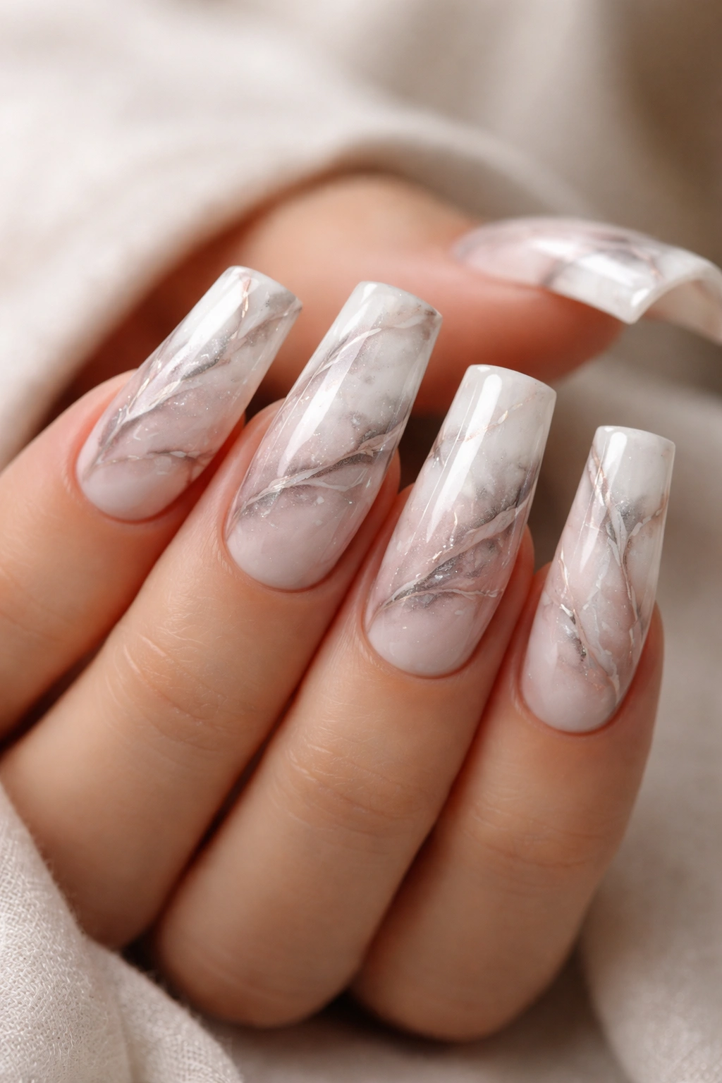 Close-up of marble effect duck nails with veining pattern in white and gray