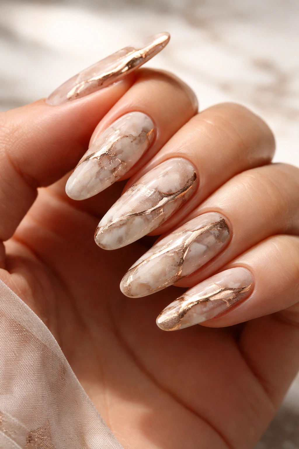 Marble veining with metallic accents on long oval nails