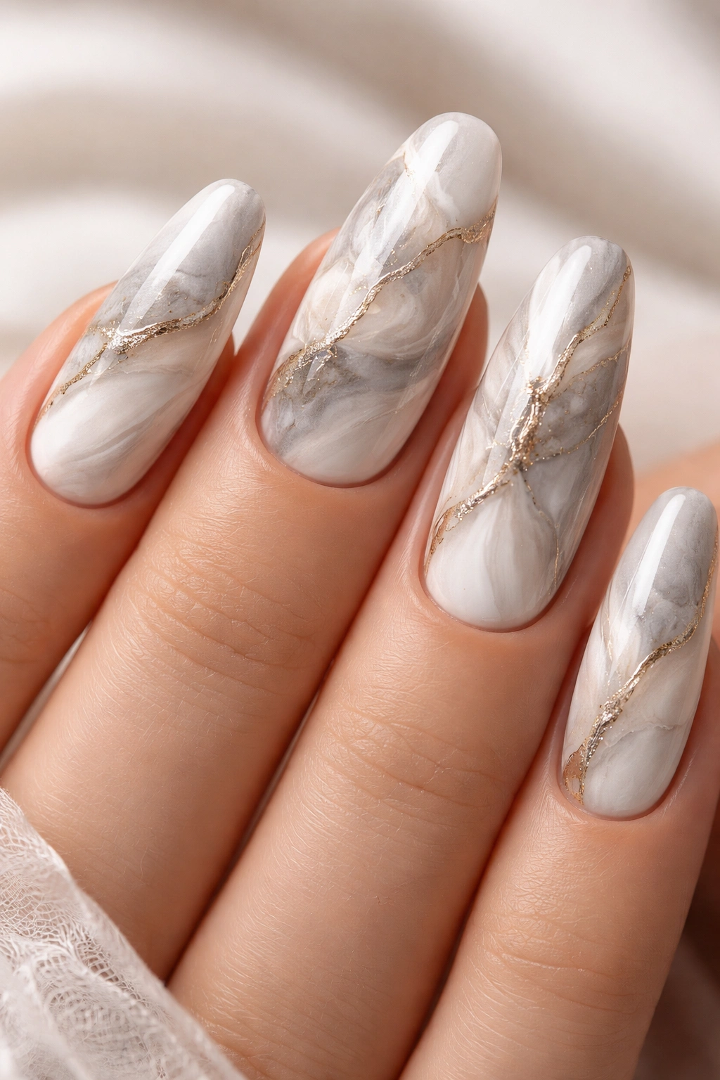 Close-up of nails with white gray beige marble veining on long nails
