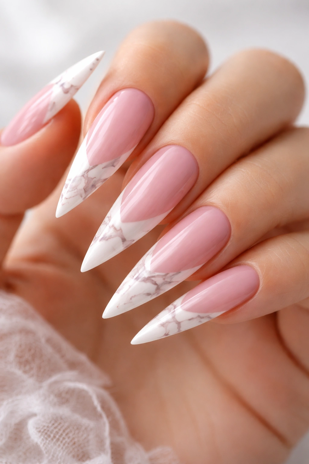 Close-up of a hand with marble pink and white stilettos nails