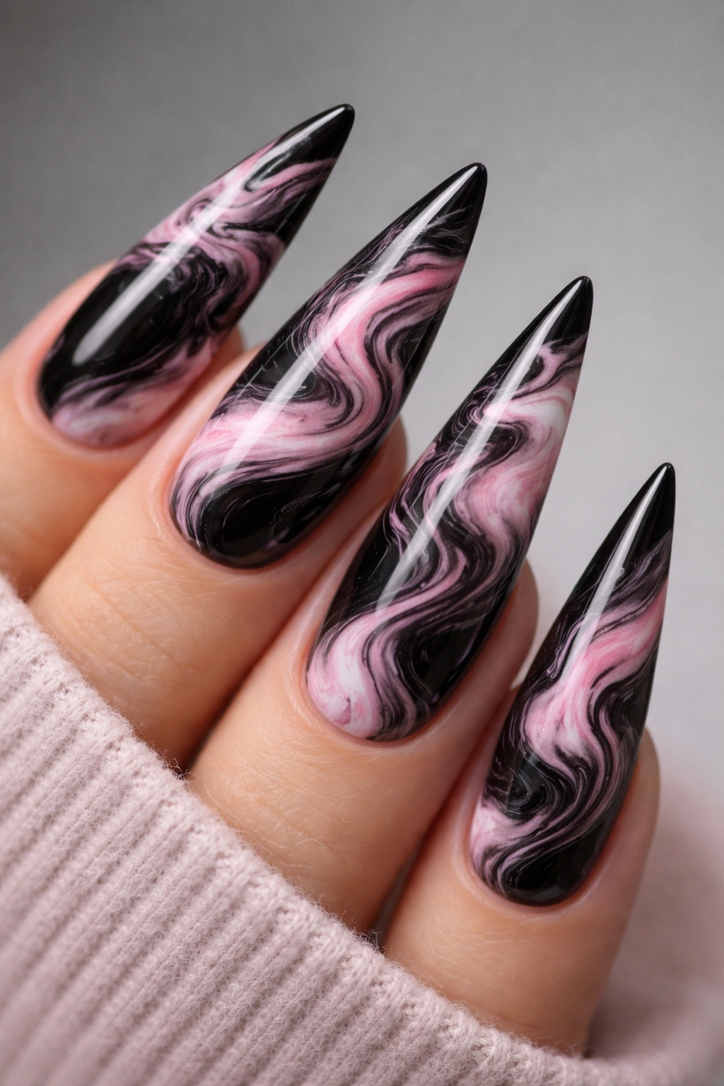 Close-up of black and pink marble-styled stiletto nails