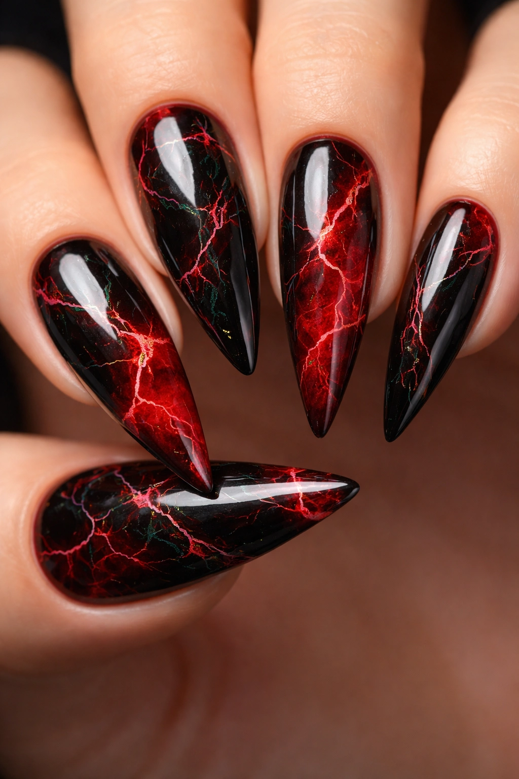 Close-up of marble black and red stiletto nails with irregular veins