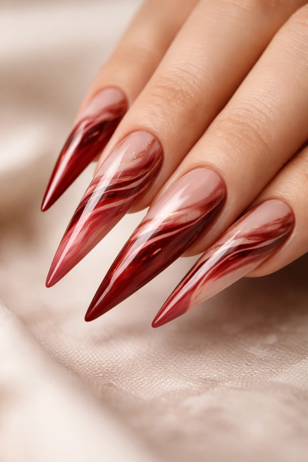 Close-up of marbled cherry red and nude stiletto nails