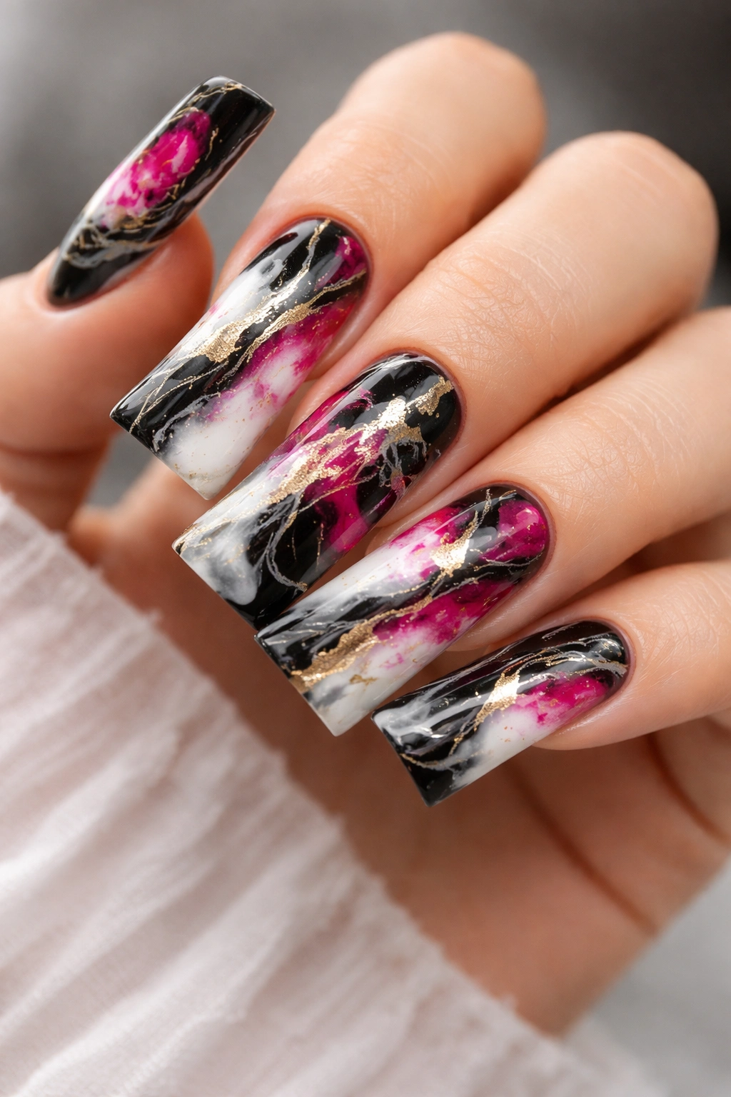 Close-up of marble-patterned duck nails with black-white veining and pink-gold accents