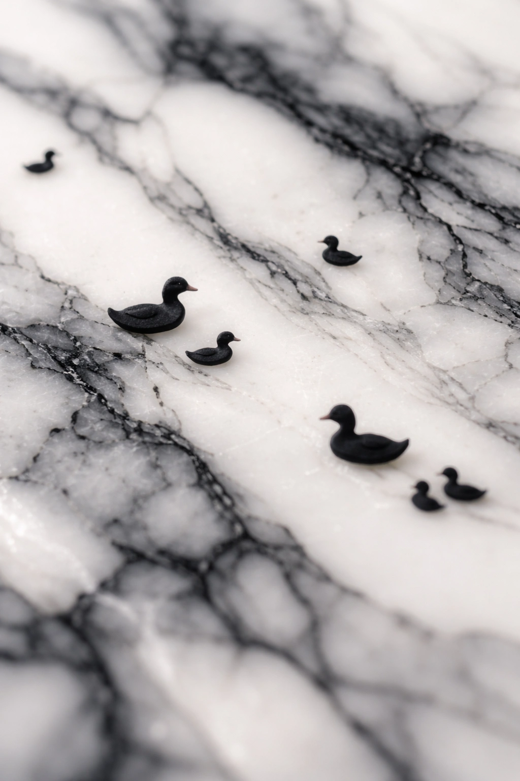 Close-up of marble nail art with duck silhouettes embedded in black veining.