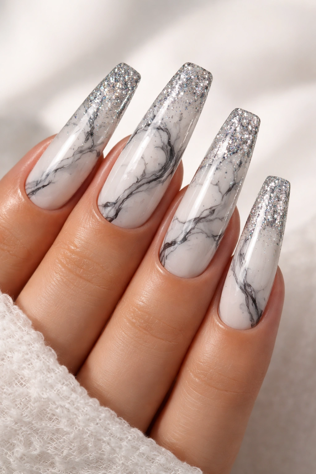 Close-up of marble-veined coffin nails with glitter tips