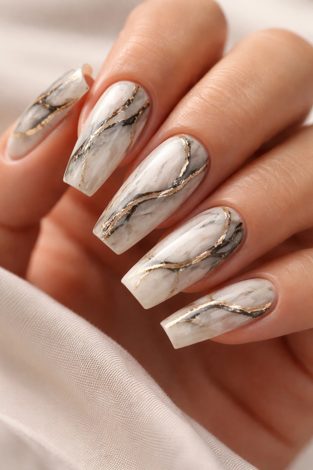 Curved coffin nails with marble swirls and gold accents