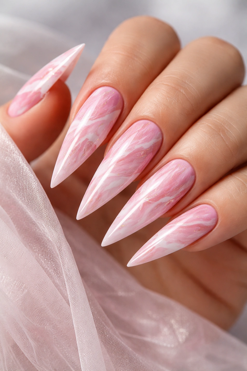 Pink and white marble stiletto nails on a hand