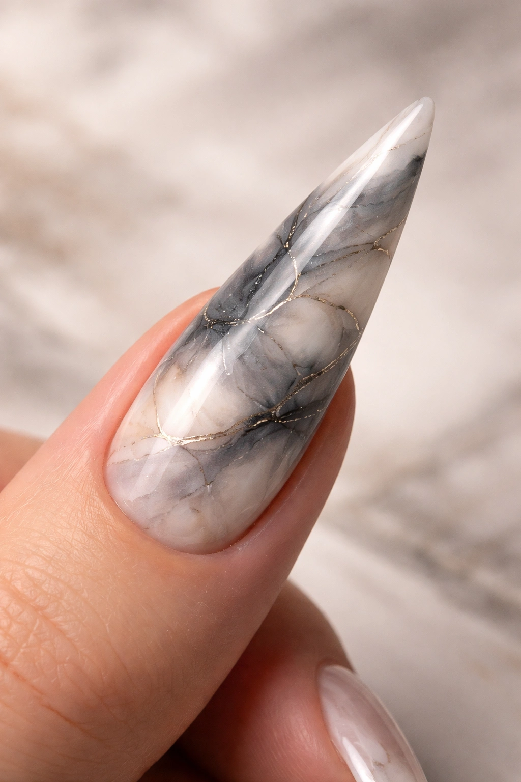 Stiletto nail with marble watercolor swirl in gray cream and charcoal