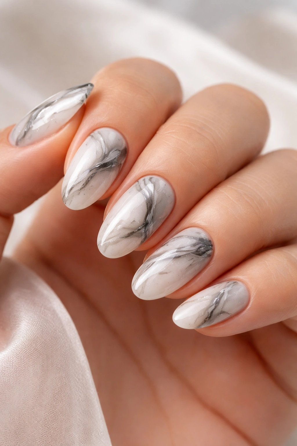 Close-up of marble swirl nails with white base and gray veins