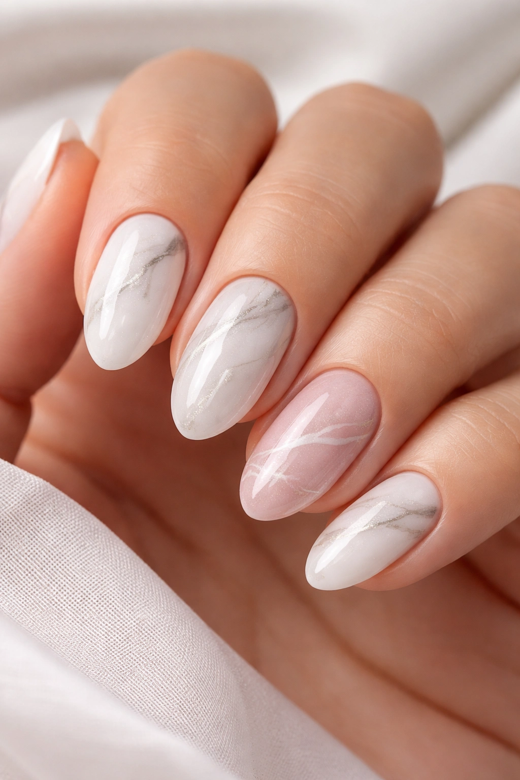 Close-up of nails with subtle marble patterns in white-gray and rose quartz tones