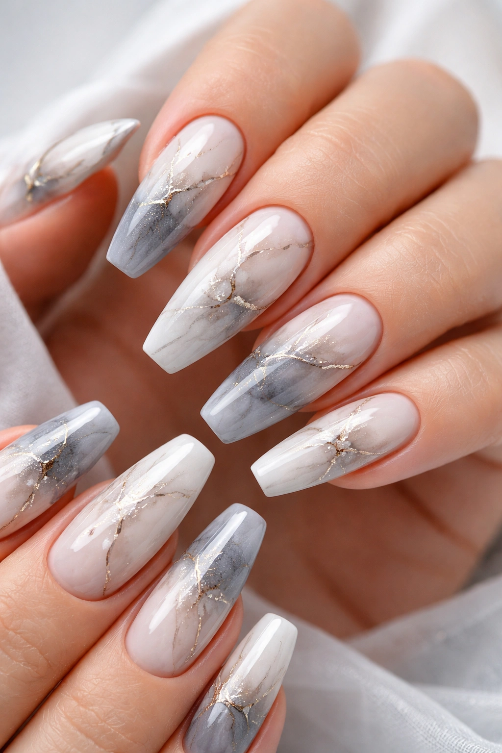 Close-up marble ombre nails with white-gray gradient and veining