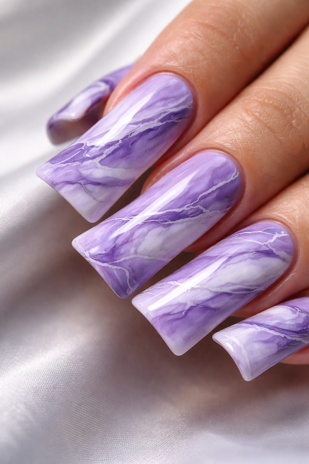 Close-up of purple and white marble duck nail on a finger