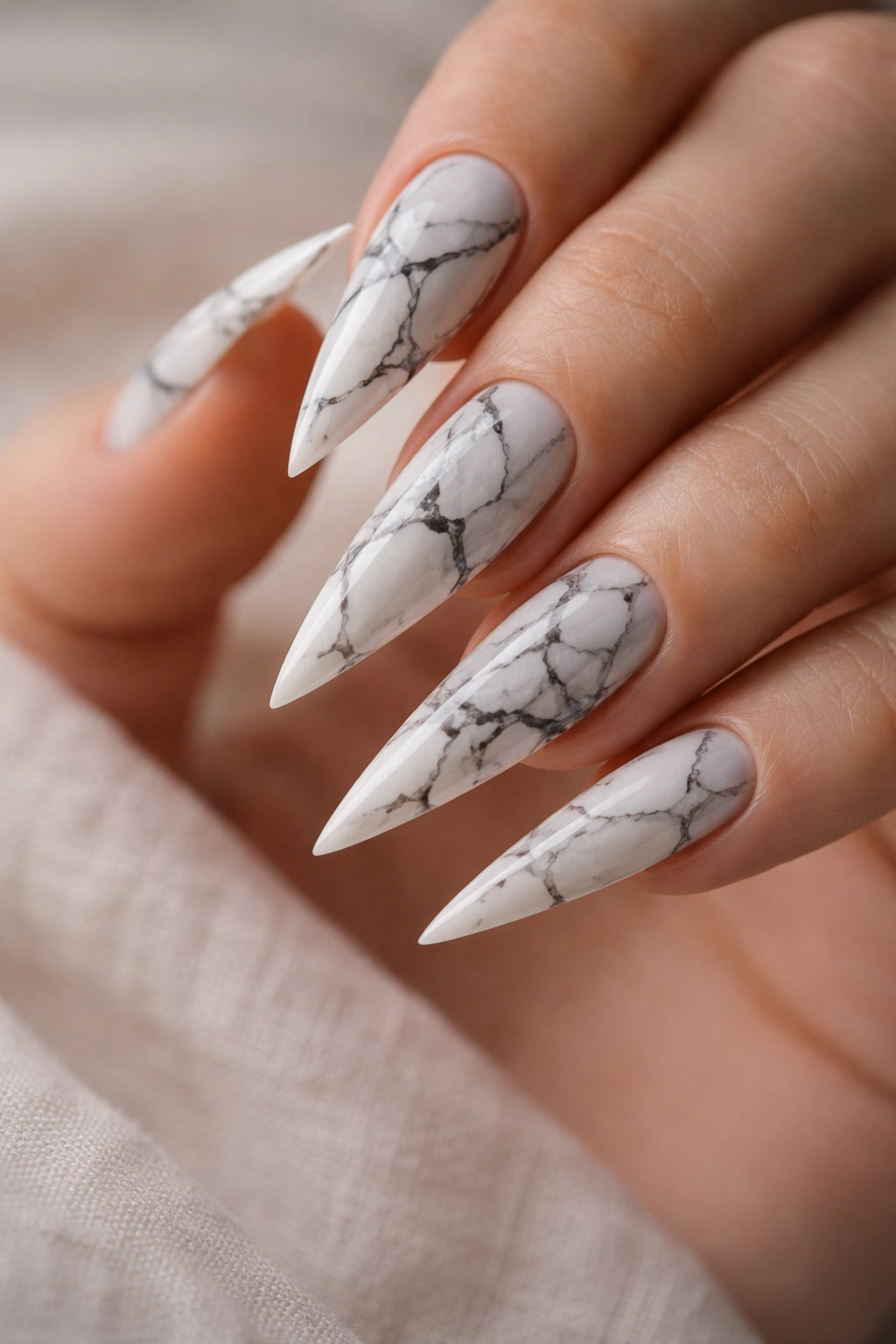 Marble print stiletto nails with black veining on light base
