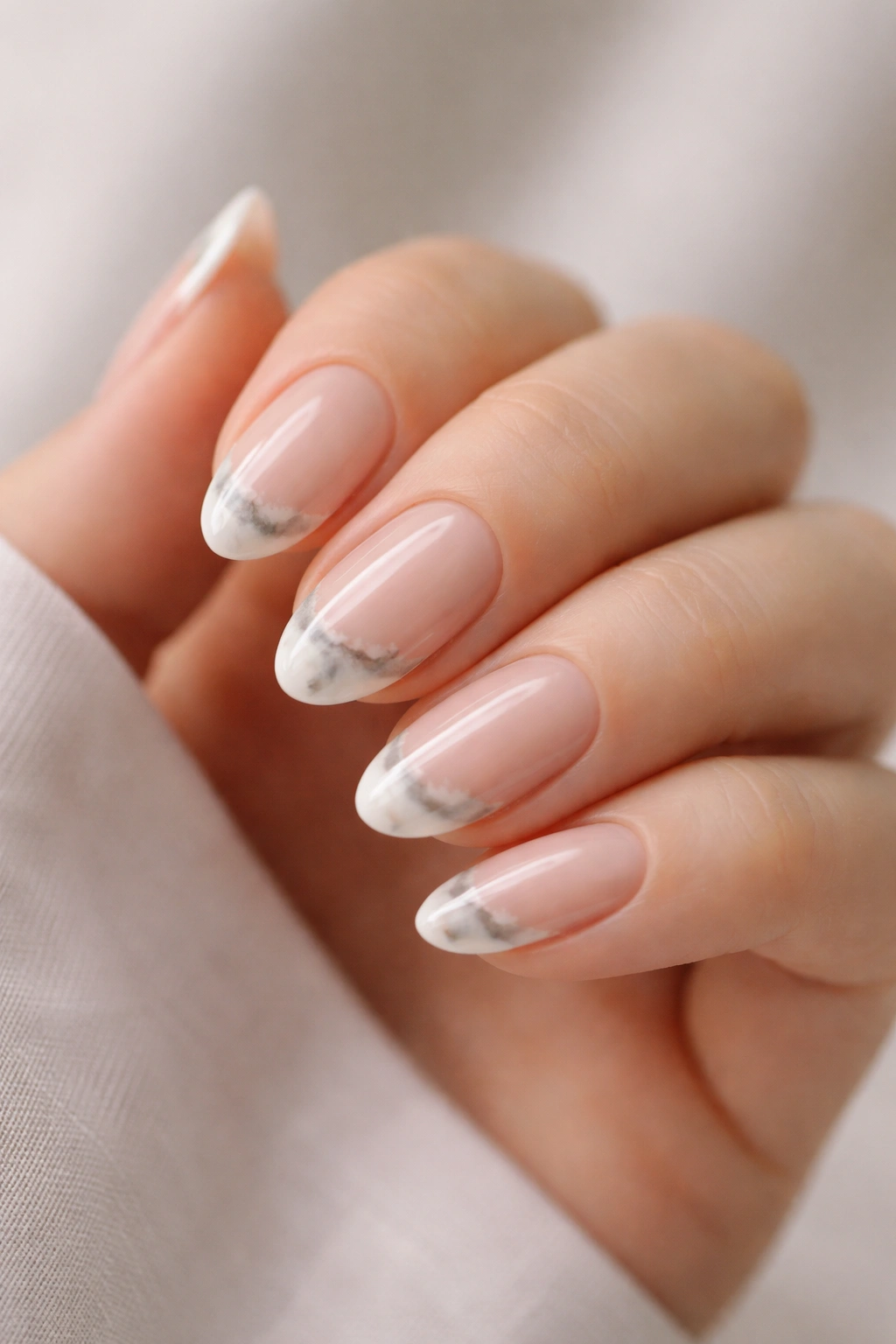 Close-up of marbled French tips on short almond nails