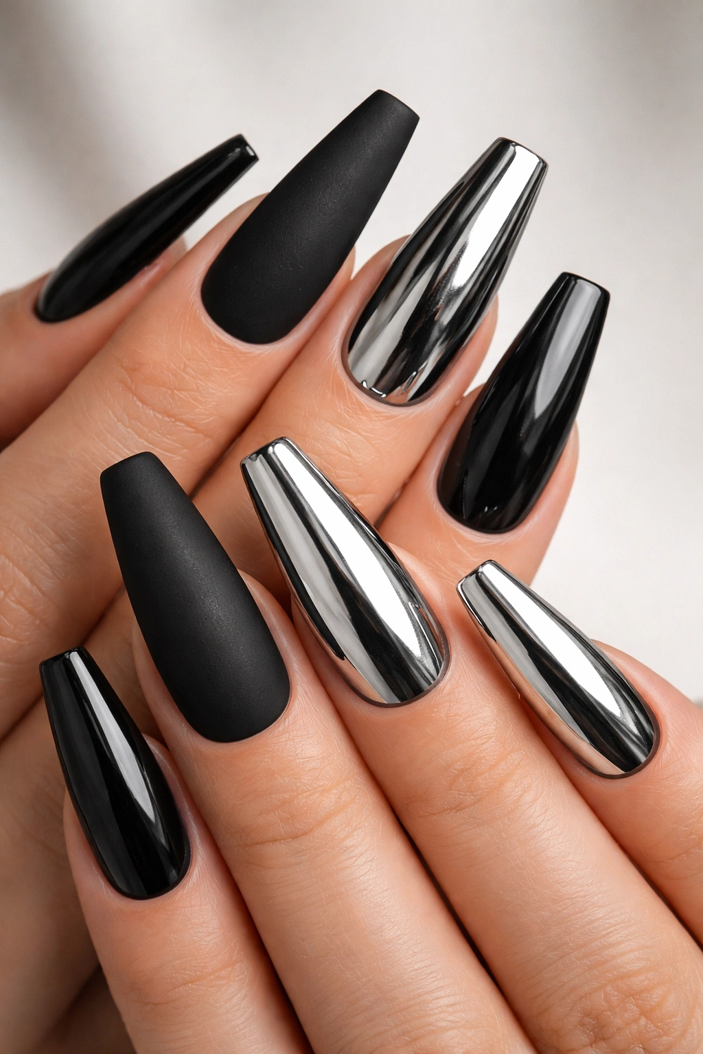 Matte black nails paired with chrome accents on coffin nails