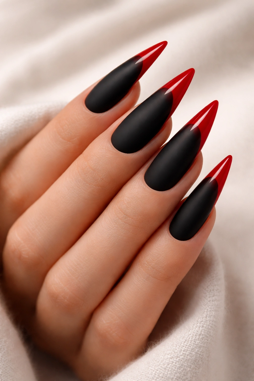 Matte black nails with glossy red tips on stiletto nails