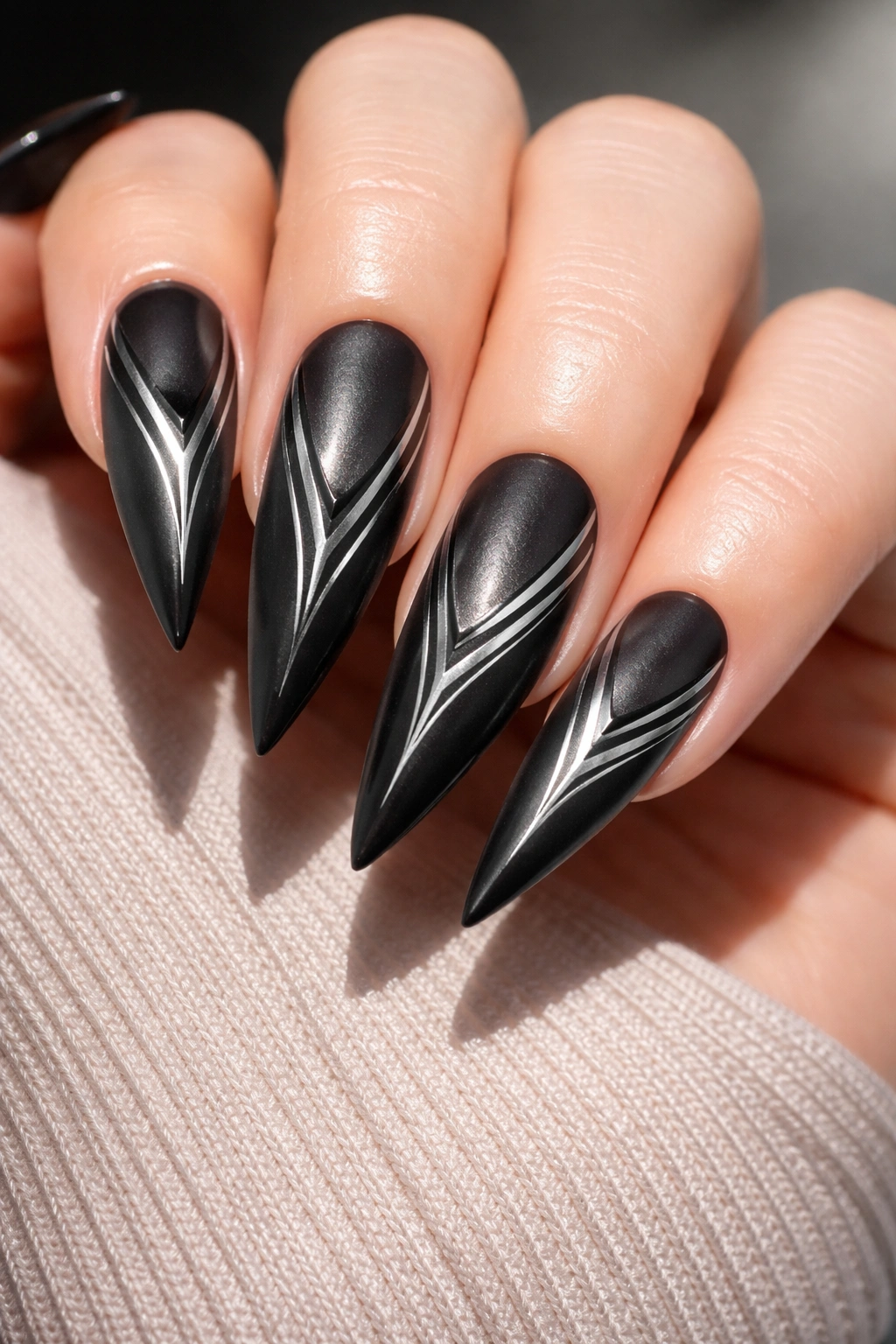 Close-up of matte black cat-eye nails with chrome lines